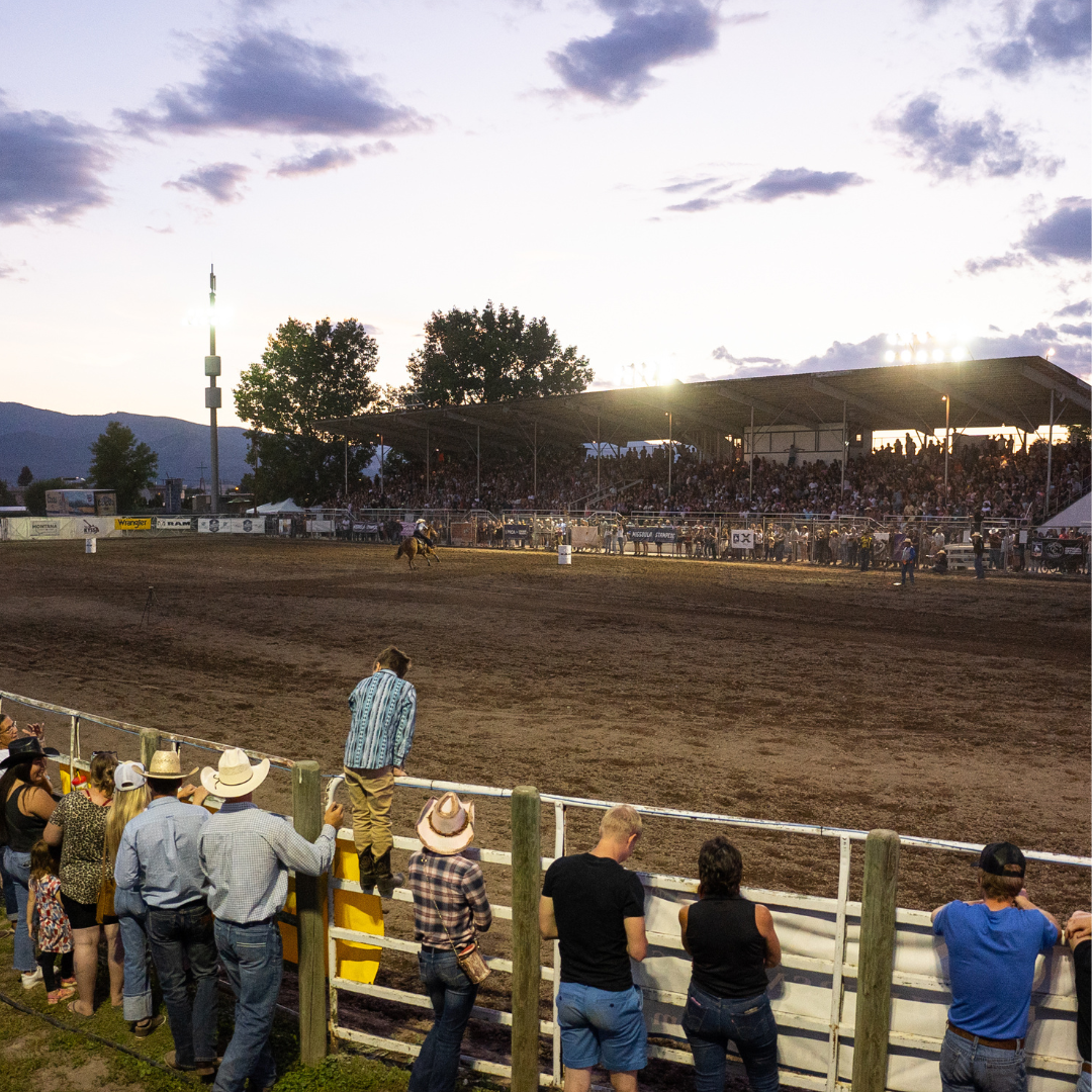 A color photo taken at dusk of the rodeo arena at the 2023 Western Montana Fair.