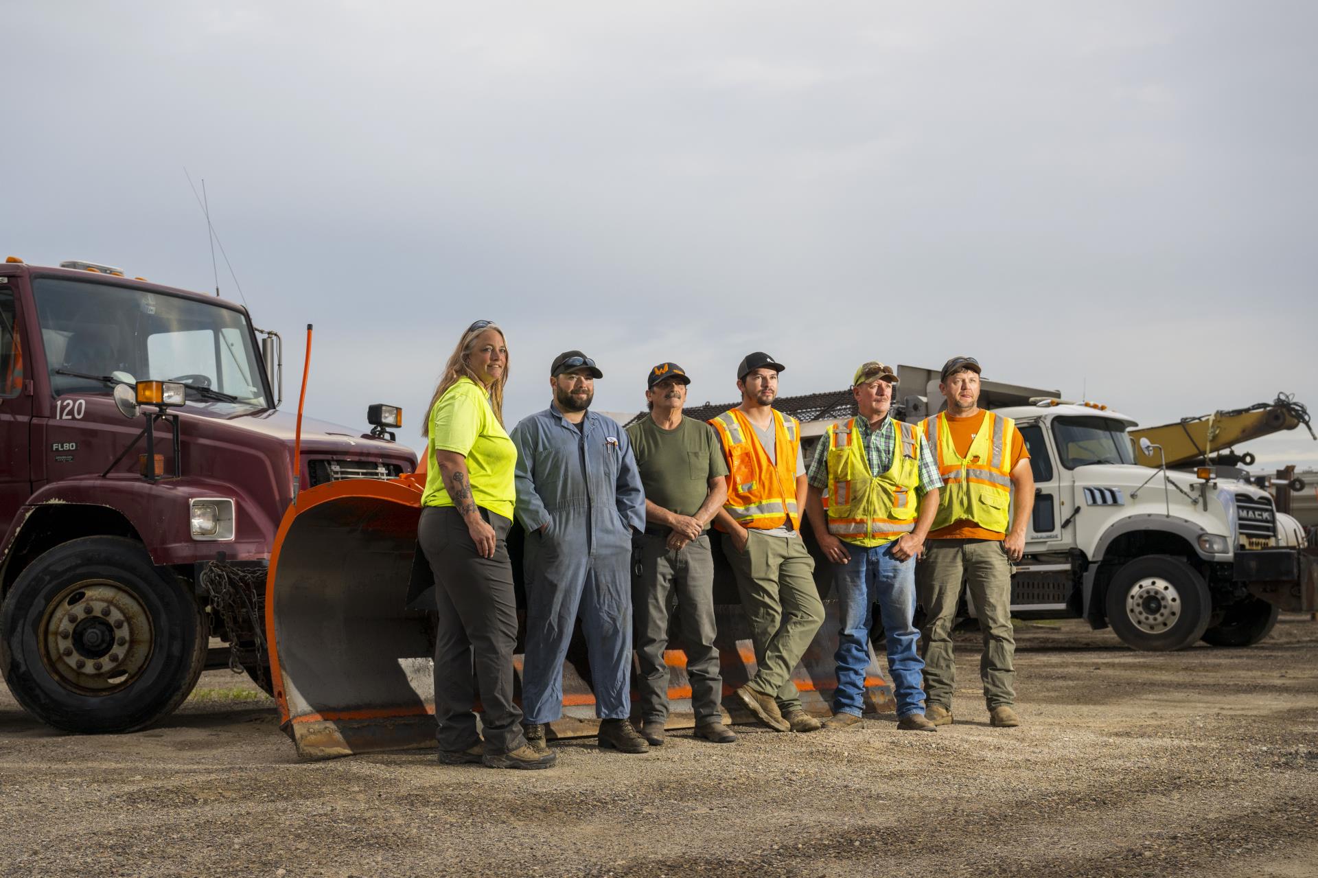 Public Works staff in a high-vis vest standing in front of machinery